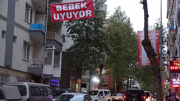 Araç gürültüsünden uyuyamayan bebeği için caddeye 'Bebek uyuyor' afişi astı
